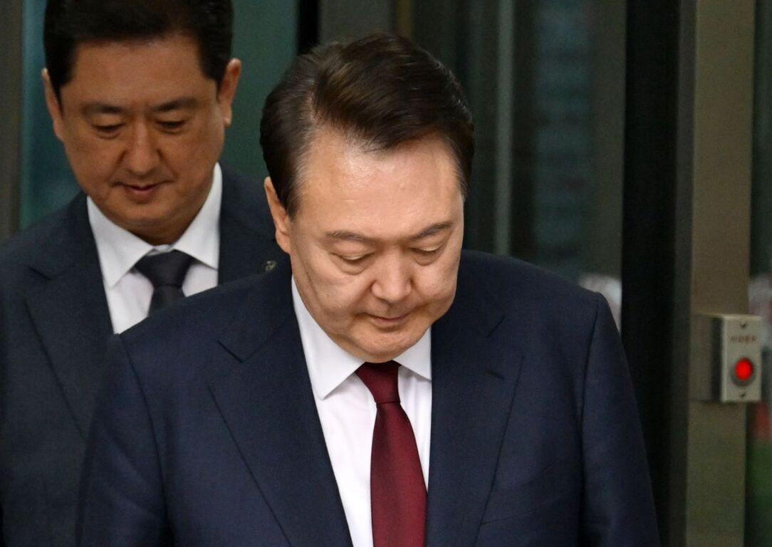 정장을 입은 두 남성이 고개를 숙이고 서 있는 모습