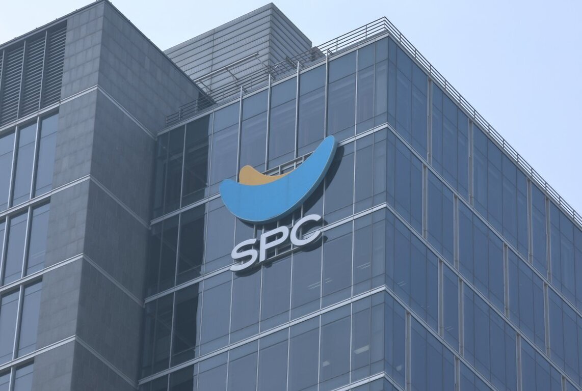유리로 된 고층 건물 외벽에 파란색과 노란색 로고와 'SPC'라는 글자가 보인다.