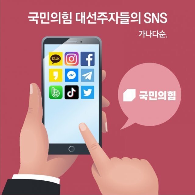 한 손이 스마트폰을 들고 다른 손가락이 화면을 가리키고 있다. 스마트폰 화면에는 카카오톡, 인스타그램, 페이스북, 네이버 밴드, 틱톡, 트위터 등 다양한 SNS 아이콘이 보인다. 상단에는 '국민의힘 대선주자들의 SNS 가나다순.'이라는 문구와 말풍선 안에 '국민의힘' 로고가 있다.