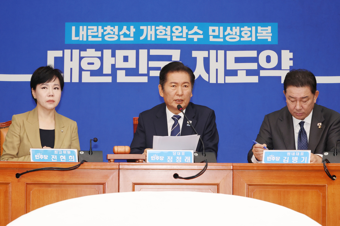 세 명의 정장 차림 인물이 책상에 앉아 회의 중이며, 배경에는 '내란청산 개혁완수 민생회복 대한민국 재도약'이라는 문구가 적혀 있다.