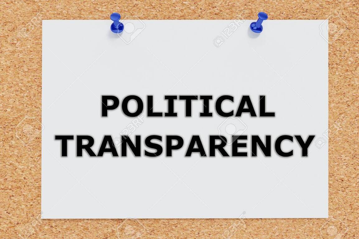 코르크 보드에 파란색 압정 두 개로 고정된 흰 종이에 'POLITICAL TRANSPARENCY'라는 검은색 글자가 적혀 있다.