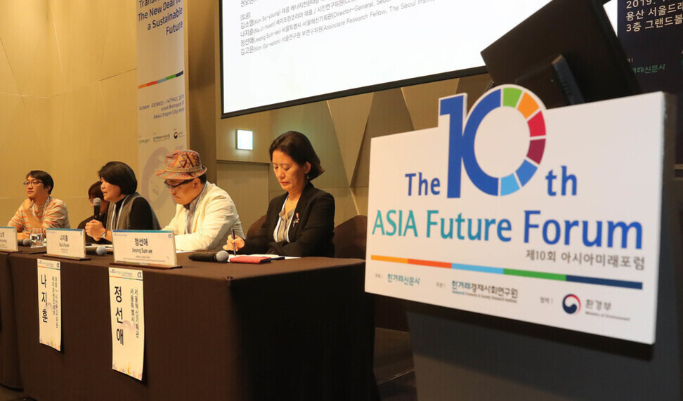정치 참여 방법, 청년과 지역사회의 실천적 변화 이끄는 길 1 네 명의 패널이 테이블에 앉아 마이크와 노트북을 사용하며 토론하고 있으며, 앞에는 '제10회 아시아미래포럼'이라고 적힌 안내판이 있다.