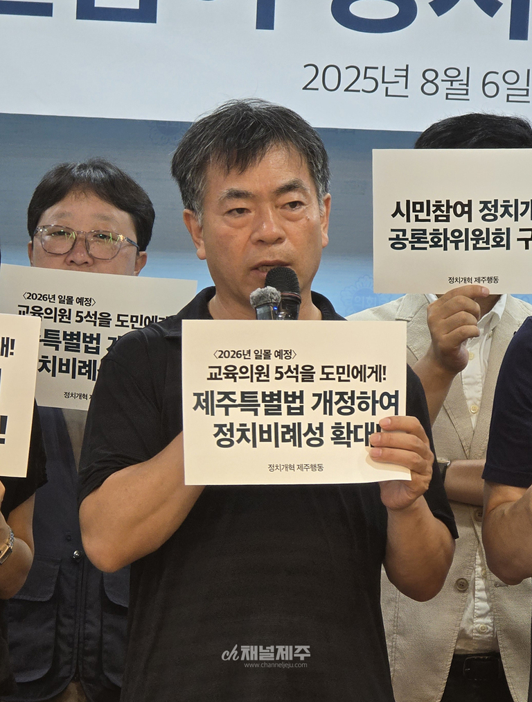 여러 명의 남성이 피켓을 들고 기자회견을 하고 있다. 중앙 남성은 마이크를 들고 있으며, 피켓에는 '2026년 임용 예정 교육위원 5석을 도민에게! 제주특별법 개정하여 정치비례성 확대'라는 문구가 적혀 있다.
