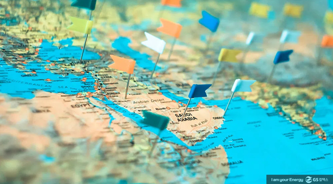 여러 개의 색색깔 깃발이 꽂혀 있는 세계 지도, 사우디아라비아와 중동 지역이 중심에 보임.